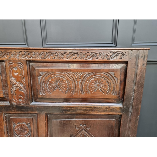 1086 - An antique carved oak box seat settle, 136cm wide.