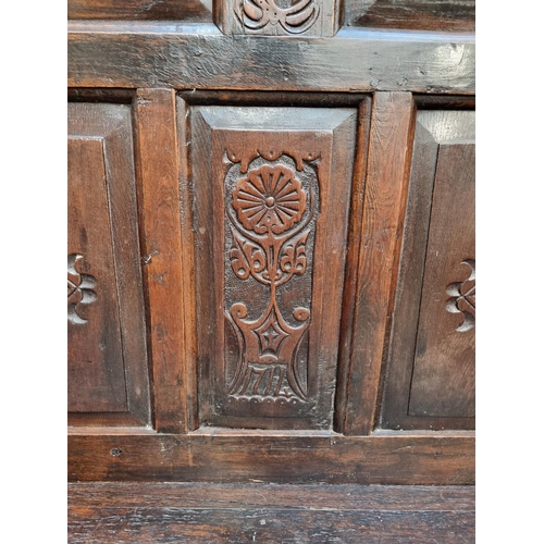 1086 - An antique carved oak box seat settle, 136cm wide.