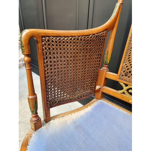 1087 - A pair of late Victorian satinwood and painted bergere chairs, (cane lacking to arms of one).... 