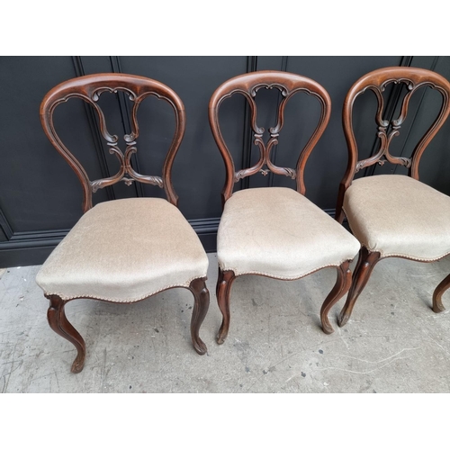 1096 - A set of four Victorian rosewood balloon back dining chairs.