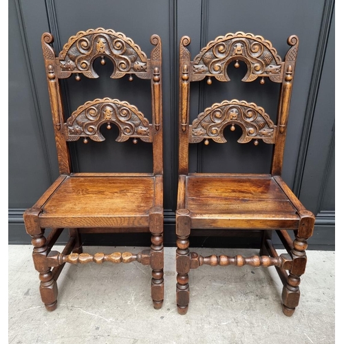 1098 - A pair of carved oak Derbyshire chairs, by Waring & Gillow.