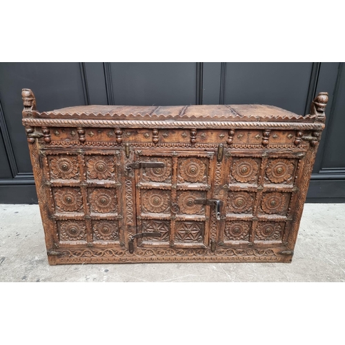 1115 - An Indian carved hardwood chest, with small central cupboard door, 97.5cm wide. ... 