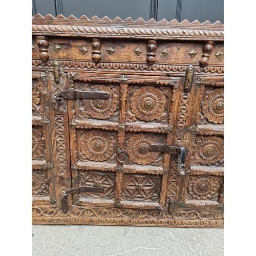 1115 - An Indian carved hardwood chest, with small central cupboard door, 97.5cm wide. ... 