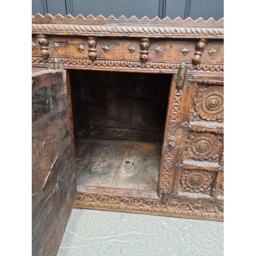 1115 - An Indian carved hardwood chest, with small central cupboard door, 97.5cm wide. ... 