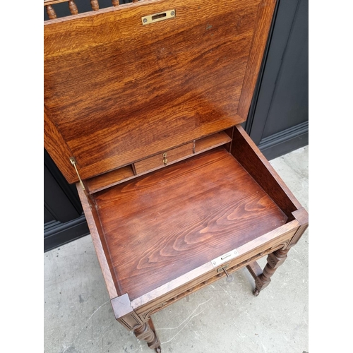 1121 - An unusual late Victorian oak Davenport, 61cm wide.