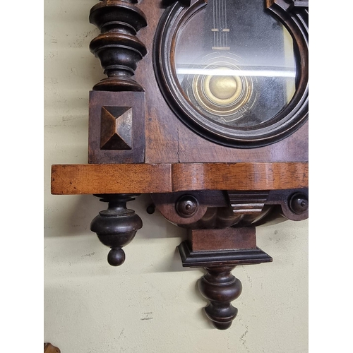 1124 - An antique walnut Vienna style wall clock, spring driven, 92cm high, with pendulum.