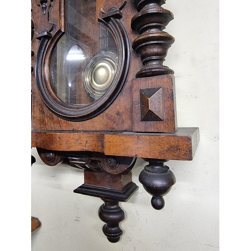 1124 - An antique walnut Vienna style wall clock, spring driven, 92cm high, with pendulum.