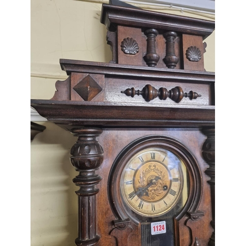 1124 - An antique walnut Vienna style wall clock, spring driven, 92cm high, with pendulum.