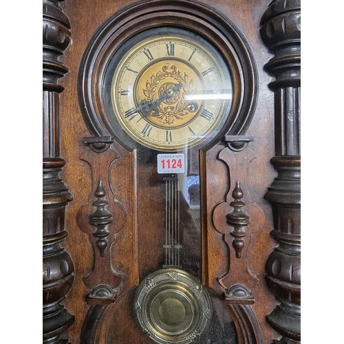 1124 - An antique walnut Vienna style wall clock, spring driven, 92cm high, with pendulum.