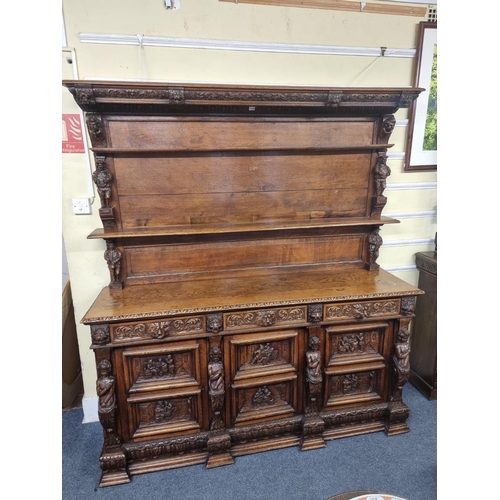 1128 - A Victorian carved oak dresser and rack, incorporating caryatid figures and panels of tavern scenes,... 