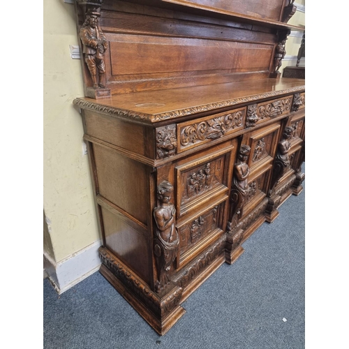 1128 - A Victorian carved oak dresser and rack, incorporating caryatid figures and panels of tavern scenes,... 