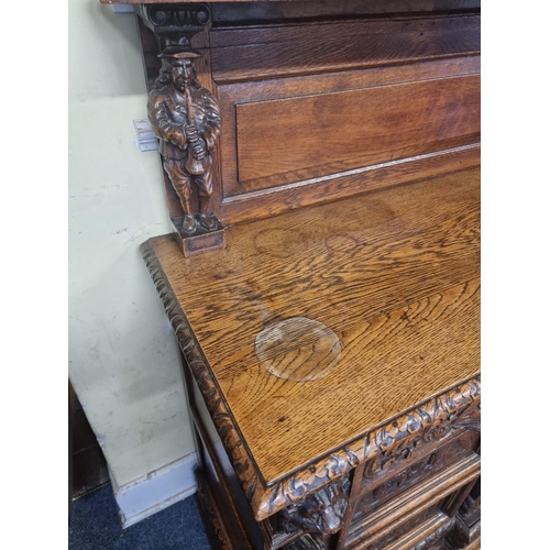 1128 - A Victorian carved oak dresser and rack, incorporating caryatid figures and panels of tavern scenes,... 