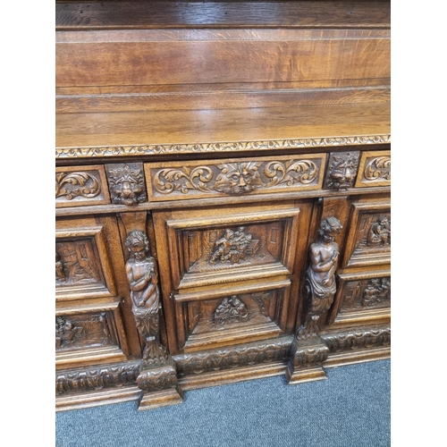 1128 - A Victorian carved oak dresser and rack, incorporating caryatid figures and panels of tavern scenes,... 