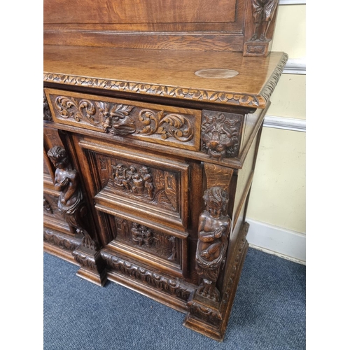 1128 - A Victorian carved oak dresser and rack, incorporating caryatid figures and panels of tavern scenes,... 