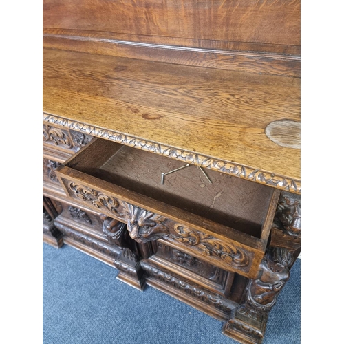 1128 - A Victorian carved oak dresser and rack, incorporating caryatid figures and panels of tavern scenes,... 