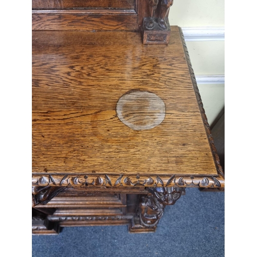 1128 - A Victorian carved oak dresser and rack, incorporating caryatid figures and panels of tavern scenes,... 