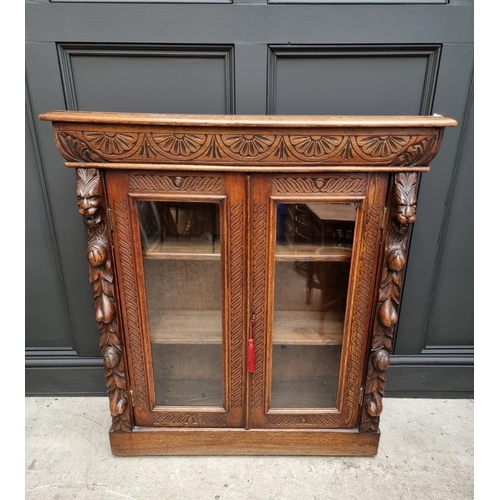 1130 - A late Victorian carved oak bookcase, 91cm wide; together with a 1920s oak and cane open bookcase, 6... 