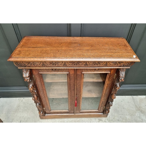 1130 - A late Victorian carved oak bookcase, 91cm wide; together with a 1920s oak and cane open bookcase, 6... 