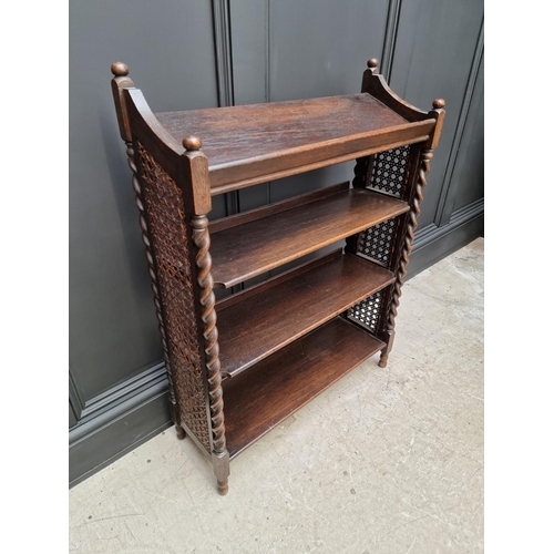 1130 - A late Victorian carved oak bookcase, 91cm wide; together with a 1920s oak and cane open bookcase, 6... 