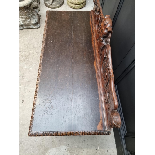 1141 - A late Victorian carved oak low hall table, with a lateral frieze drawer, 127cm wide, (reduced in he... 