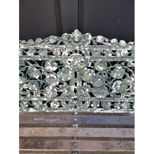 1144 - An old green painted cast iron garden bench, 131cm wide.