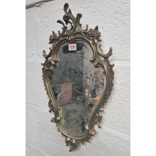 1235 - A Louis XV style cast brass frame wall mirror, 54 x 31cm. 