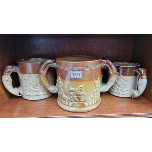 1257 - Two Victorian stoneware loving cups, largest 16.5cm high; and a similar tyg, (chips to each).&n... 