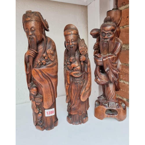 1280 - Two similar Chinese carved bamboo figures, largest 35.5cm high; together with another carved wood fi... 