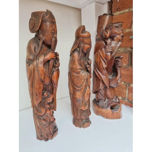 1280 - Two similar Chinese carved bamboo figures, largest 35.5cm high; together with another carved wood fi... 