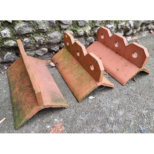 1676 - Three large decorative composition red stone roof tile ridges, 45cm wide.