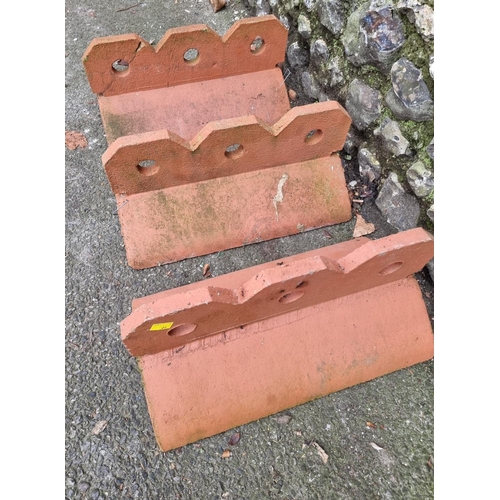 1676 - Three large decorative composition red stone roof tile ridges, 45cm wide.