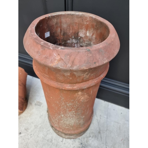 1694 - A terracotta chimney pot, 61cm high x 20cm wide; together with a similar chimney top.... 