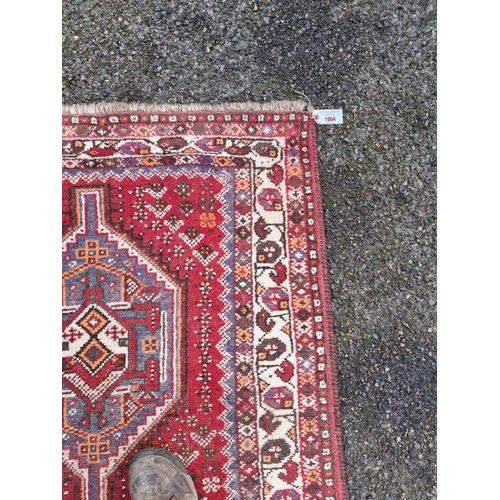 1004 - A Persian rug, having two medallions, with floral borders, 160 x 105cm.