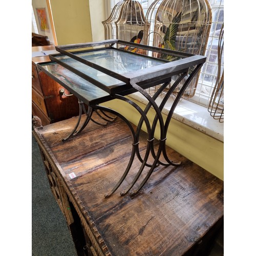 1114 - A nest of three steel and glass occasional tables, largest 54.5cm wide, (largest lacking glass)... 