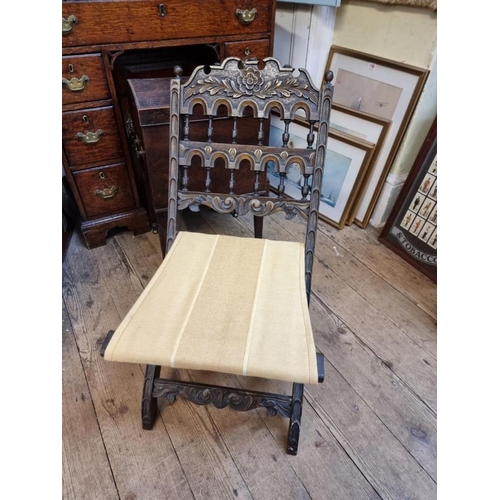 1088 - A small old carved oak and parcel gilt folding chair. 