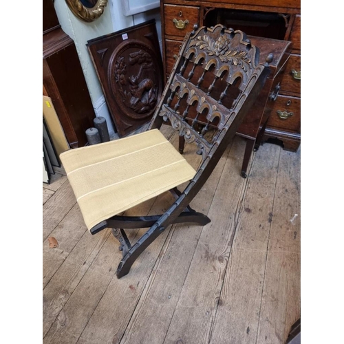 1088 - A small old carved oak and parcel gilt folding chair. 