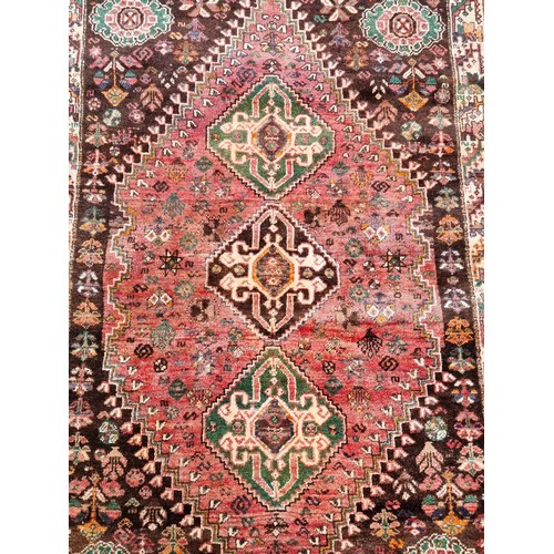 1009 - A Persian rug, having three central medallions, floral cartouches to each corner with animals t... 