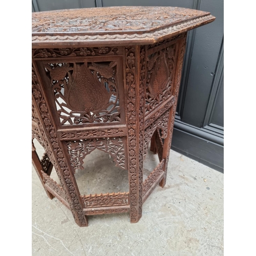 1035 - An Indian carved and pierced hardwood octagonal folding table, 61cm wide. 