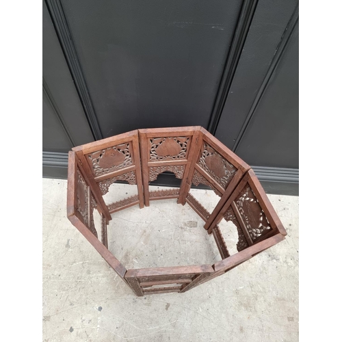 1035 - An Indian carved and pierced hardwood octagonal folding table, 61cm wide. 