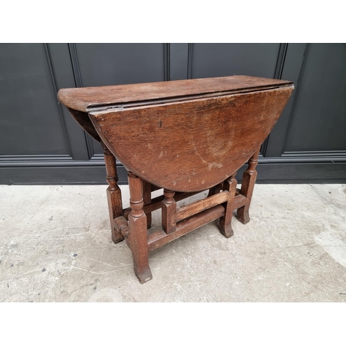 1050 - An antique oak gateleg table, 89cm wide. 