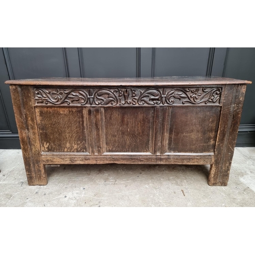 1053 - A 17th century oak panelled coffer, with unusual carved frieze, 138cm wide. 