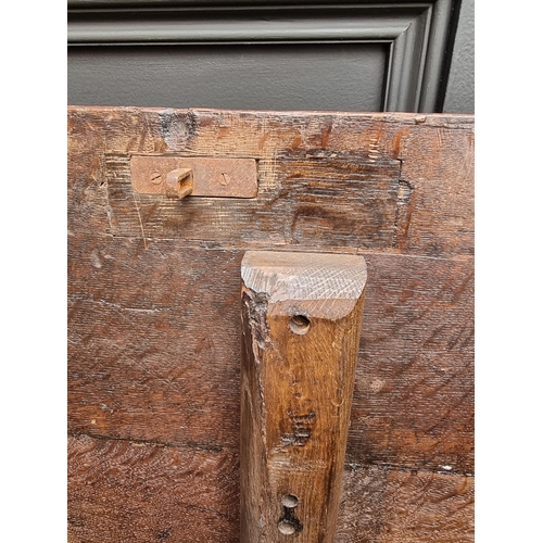 1053 - A 17th century oak panelled coffer, with unusual carved frieze, 138cm wide. 