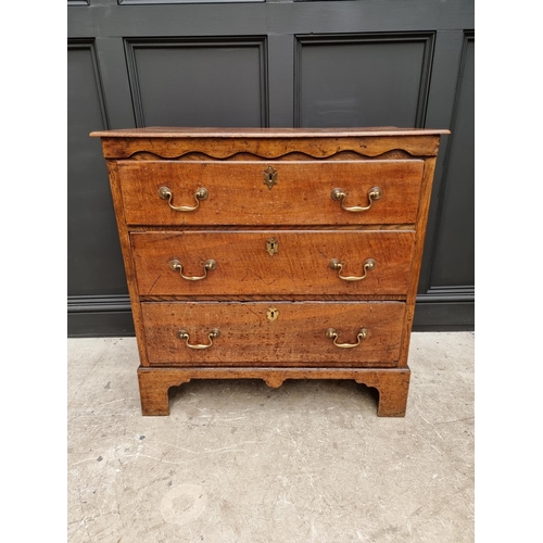 1058 - An 18th century oak three drawer chest, with moulded frieze, 89.5cm wide. 