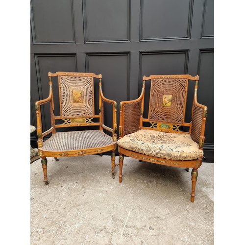 1074 - A pair of late Victorian satinwood and painted bergere chairs, (cane lacking to arms of one and seat... 