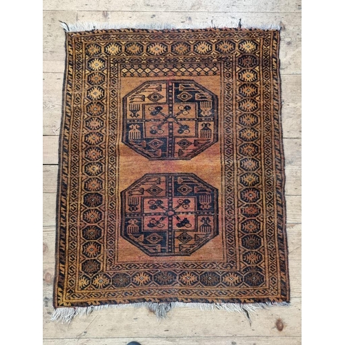 1013 - A small Afghan rug, on an orange ground, with two central medallions, 115 x 90cm.