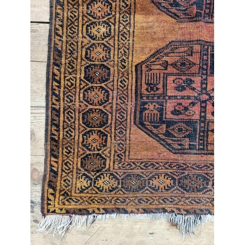 1013 - A small Afghan rug, on an orange ground, with two central medallions, 115 x 90cm.