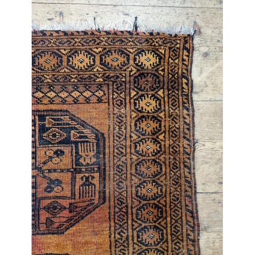 1013 - A small Afghan rug, on an orange ground, with two central medallions, 115 x 90cm.