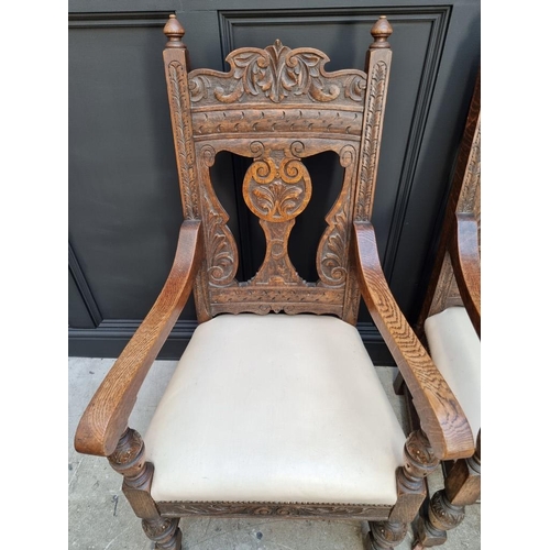 1017 - A pair of late Victorian carved oak open armchairs, with studded cream leather seats.... 