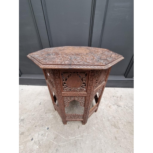 1035 - An Indian carved and pierced hardwood octagonal folding table, 61cm wide. 