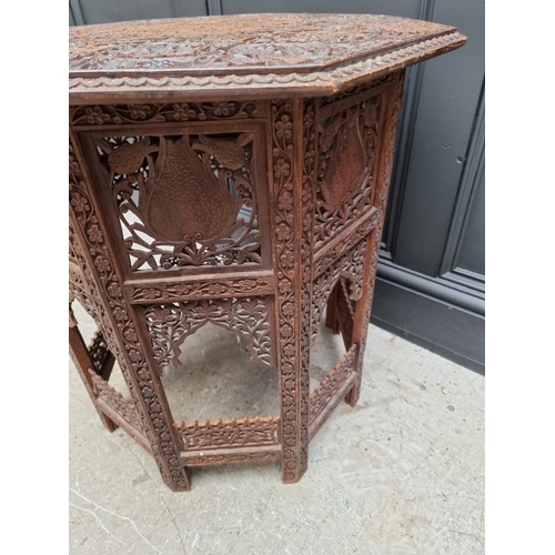 1035 - An Indian carved and pierced hardwood octagonal folding table, 61cm wide. 